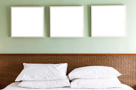 Empty picture frame above the bed in a modern bedroomの写真素材