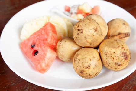 Mixed fruit plate on white brown tableの写真素材