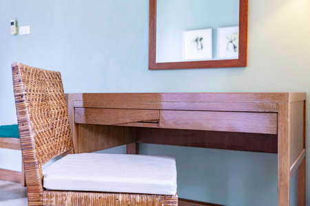 Brown rattan chair and wooden makeup table in modern bedroomの写真素材