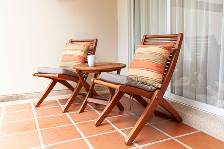 Brown wooden chairs and brown cushions on the balconyの写真素材