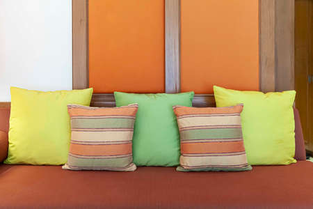 Green and brown cushions on a brown fabric long sofa in a modern home living roomの写真素材