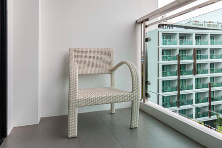 Empty white rattan chair on balcony on high rise buildingの写真素材