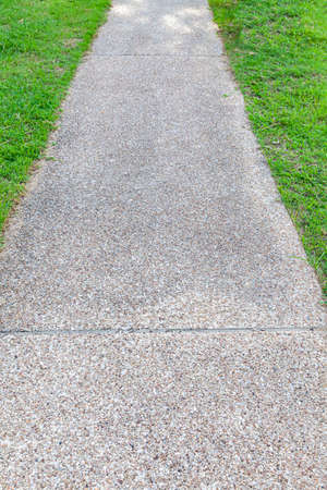 Long concrete walkway in the summer green gardenの写真素材
