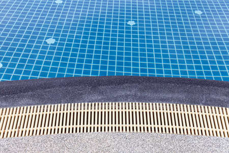 Wide swimming pool and brown stone floor inside the villaの写真素材