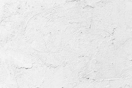 The walls of the cement building are painted white with a rough surfaceの写真素材