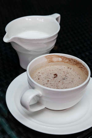 The coffee mug placed on the black wood tableの写真素材