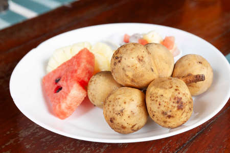 Mixed fruit plate on white brown tableの写真素材