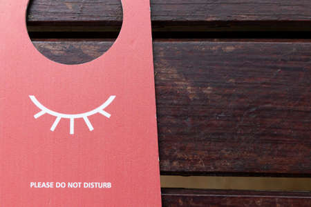 Do not disturb paper signs are placed on wooden tables inside the hotelの写真素材