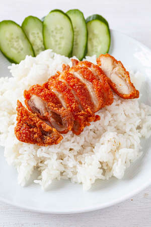Fried Chicken Rice And cucumber on a white plate isolated on a white backgroundの写真素材