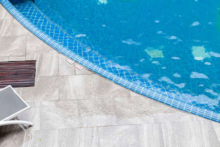 Wide swimming pool and brown stone floor inside the villaの写真素材