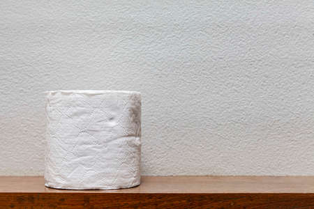 New rolls of tissue paper on a wooden shelf in the bathroomの写真素材