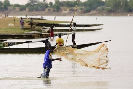 Mopti,Mali - August 16,2009 : Youth fishing in the Niger River, fishing in the river is still ongoing in the traditional way by throwing the net from the shore.のeditorial素材