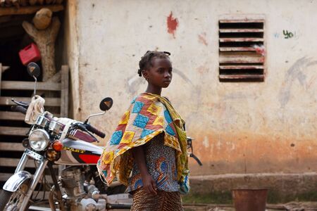 Gaoua, Burkina Faso - August 12.2009: Girl of the Lobi ethnic group notes with curiosity to Western tourists, the Lobi are among the poorest ethnic groups in the countryのeditorial素材