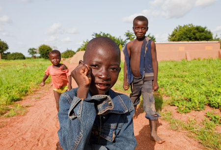 Country Bissa, Burkina Faso - August 9, 2009: Bissa ethnic children display their skills to Western tourists, the children take advantage of views to play and get some giftsのeditorial素材