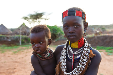 Turmi, Ethiopia, August 15, 2011: Hammer ethnic girl takes care of his brother, the Hammer are an...