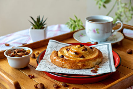 Pastry rolls with honey and dry grapes served with tea, almond and dry grapes asideの写真素材