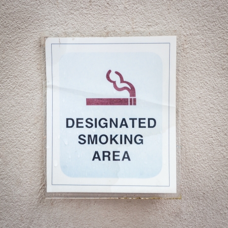 Tag for designated smoking area on wallの写真素材