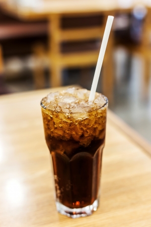 glass and cola with ice  on wood tableの写真素材