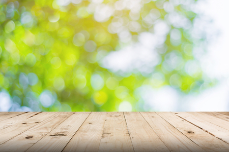 green leaf bokeh blurred and wood table for nature background green leaf bokeh blurred and wood table for nature background