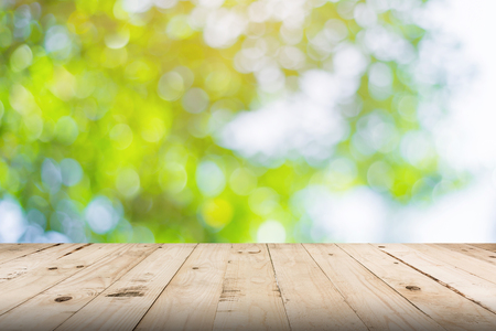 green leaf bokeh blurred and wood table for nature background