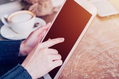 hand woman playing tablet in coffee shop with vintage tone.