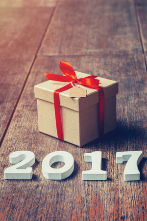 Wooden numbers forming the number 2017, For the new year 2017 on rustic wooden with gift box and red...