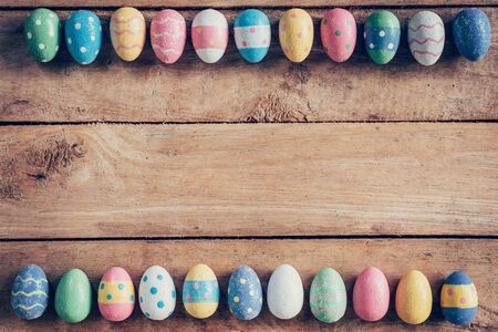 Colorful pastel easter eggs on wooden background with space. Vintage toned.の写真素材