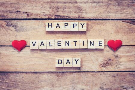 Red heart and wooden text for Happy Valentine Day on wood table background.の写真素材