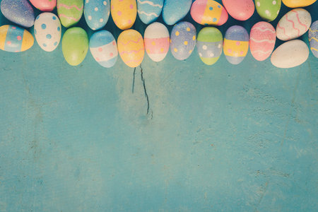 Colorful easter egg on blue pastel color wood background with space.