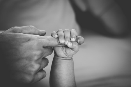 Newborn baby touching his mother handの写真素材