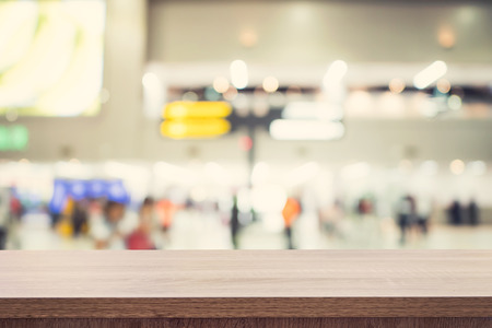 Empty wooden table for product placement or montage and blurred terminal department at airport background.の写真素材