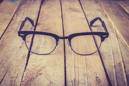 Eyeglasses Glasses with Black Frame Fashion Vintage Style on Wood Desk Backgroundの写真素材