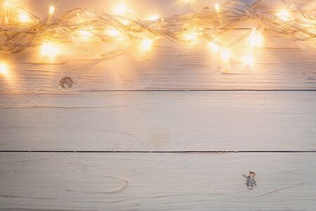 christmas background and lights garland on wood background with space.の写真素材