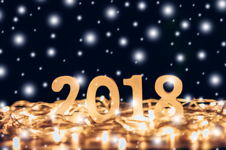 Wooden numbers forming the number 2018, For the new year and chrismas light with snow on wood table...