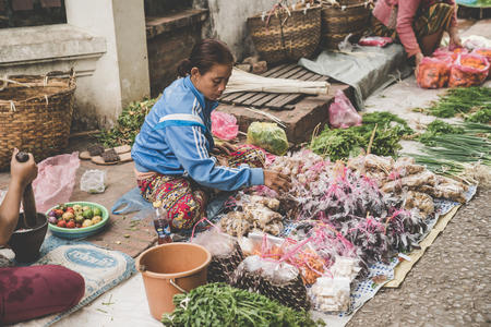 LUANG PRABANG, LAOS - NOVEMBER 13: A local Laotian Hill tribe Woman sells vegetables at the daily morning market in Luang Prabang, Laos on the 13th NOVEMBER, 2017.のeditorial素材