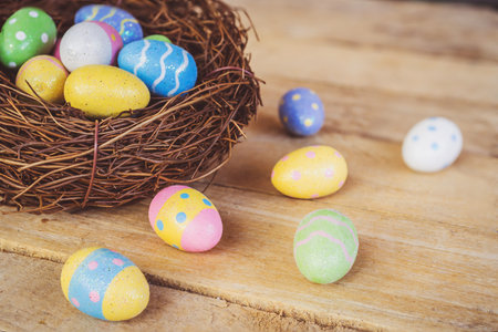 Colorful easter eggs in neat on plank wooden background with space.の写真素材