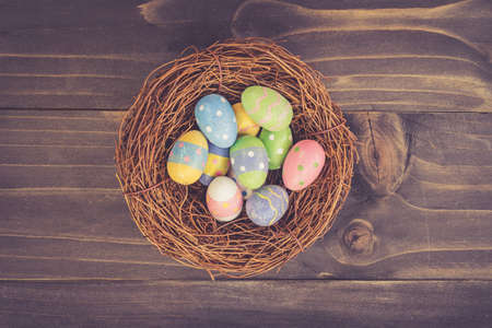 Colorful easter eggs in neat on plank wooden background with space.の写真素材