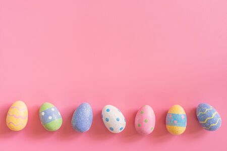 Colorful easter eggs on pink pastel color background with space.の写真素材