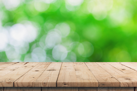 Empty wooden table top and green bokeh display montage for product with space.の写真素材