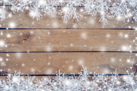 Wooden brown christmas background and snow white with snowflakes, copy space.の写真素材