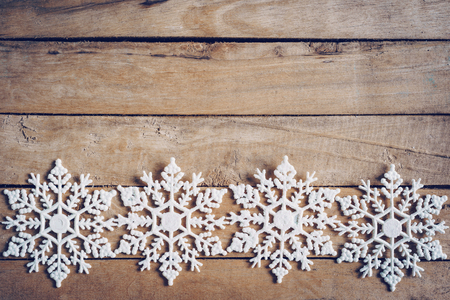 Wooden brown christmas background with snowflakes and christmas decoration.の写真素材