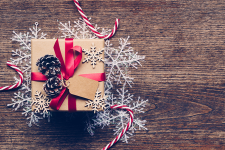 Christmas gift box placed and white snowflakes on wooden planks with space.の写真素材