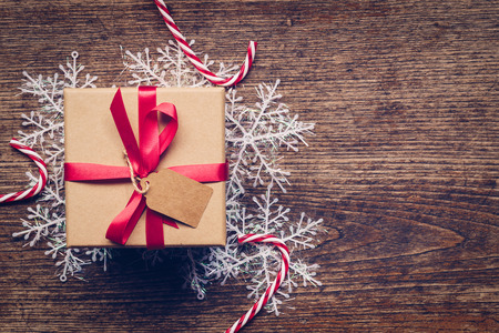 Christmas gift box placed and white snowflakes on wooden planks with space.の写真素材