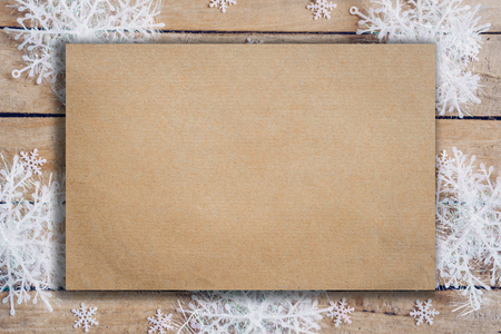Wooden brown christmas background with snowflakes and old brown paper with space.の写真素材