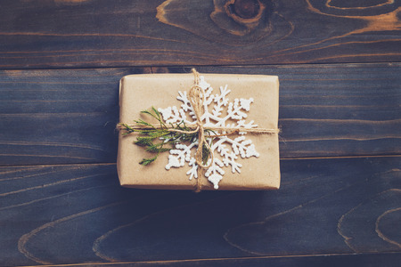 String or twine tied in a bow on kraft paper. Above gift box on wood with space.の写真素材