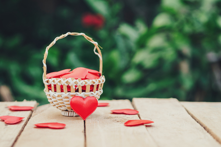 Red heart in basket on wooden table for valentine day and love concept with copy space.の写真素材