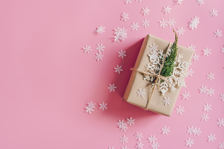 Brown gift box on the pink background with christmas decoration. Minimal styled holiday card with copy space.の写真素材