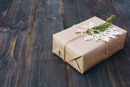 Christmas gift box placed and white snowflakes on wooden planks with space.の写真素材
