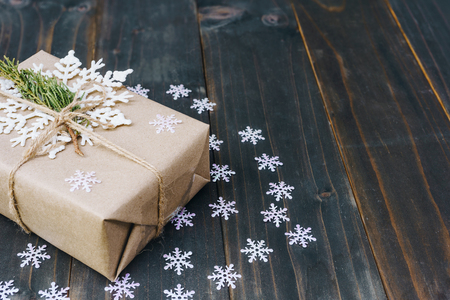 Christmas gift box placed and white snowflakes on wooden planks with space.の写真素材