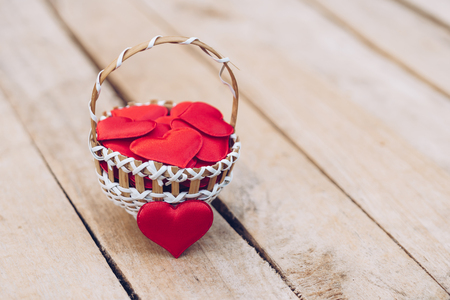 Red heart in basket on wooden table for valentine day and love concept with copy space.の写真素材